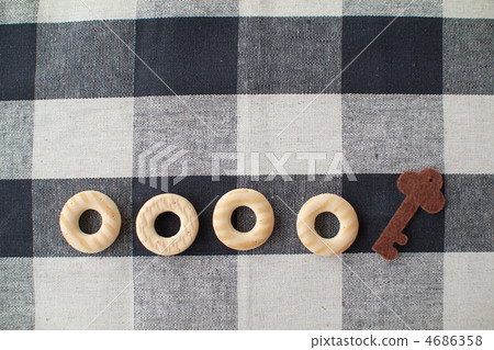 餅乾和鑰匙形狀的毛氈碎片排列在布上 4686358