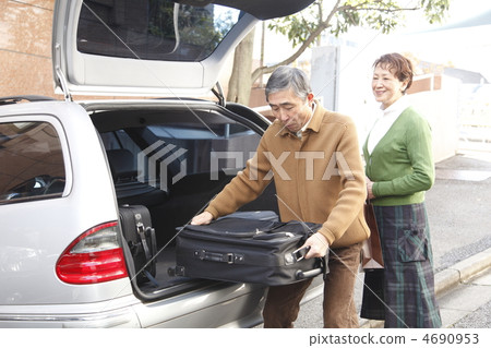 Middle-aged and married couples who take down their luggage from a car 4690953