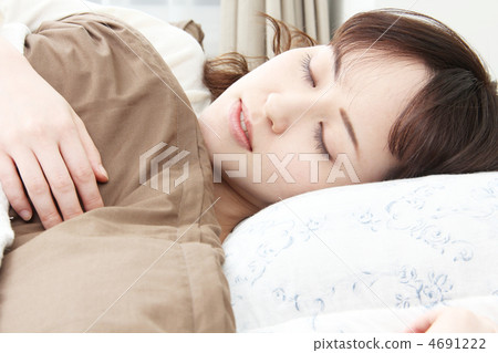 在一個充滿晨光的房間裡,一個女人睡在床上 在一個充滿晨光的房間裡,一個女人睡在床上 4691222