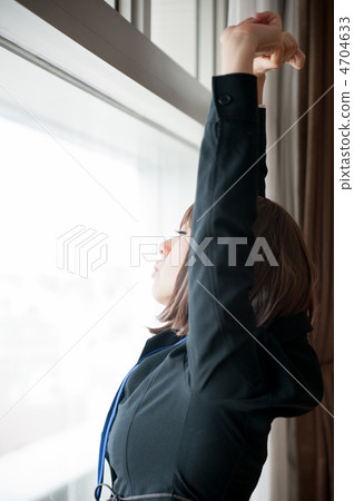 Business woman stretching while staring at the other side of the window 4704633