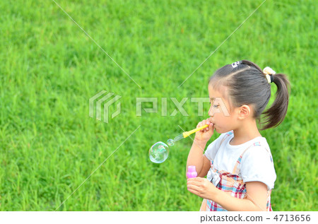 A girl that inflates soap bubbles A girl that inflates soap bubbles 4713656