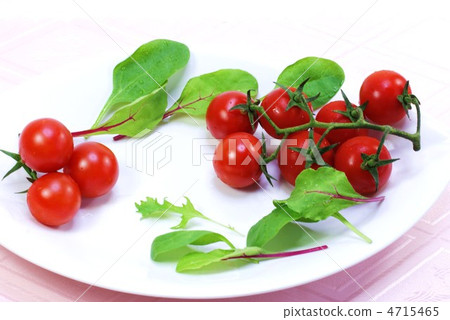 Branded mini tomato back and berry leaf / back white blur lateral position on white dish Branded mini tomato back and berry leaf / back white blur lateral position on white dish 4715465