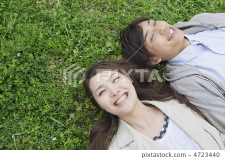 A couple lying on the lawn 4723440