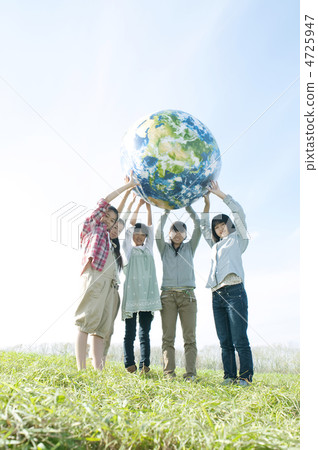 Junior high school students with Earth balls in the meadow 4725947