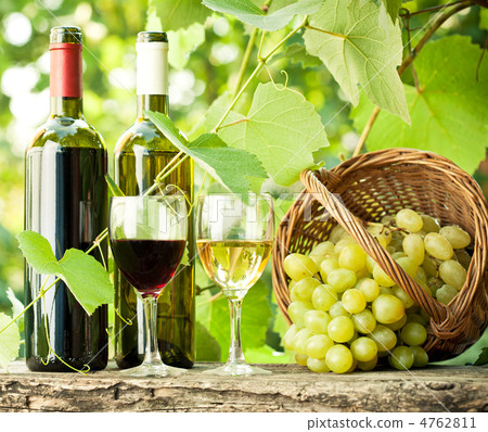 Red and white wine bottles, two glasses and grapes in basket Red and white wine bottles, two glasses and grapes in basket 4762811