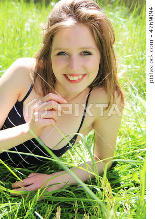 A smiling woman lying on the grass Foreigner 4769094