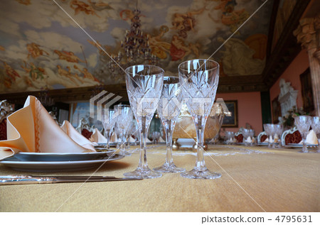 Three cut-glass gobles stand on big dinner table near knives and 4795631