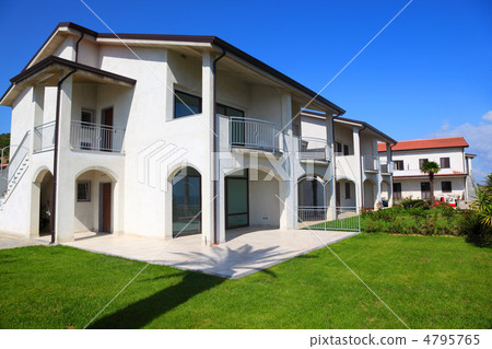 Facade of new white two-story house with garden, balcony and sta 4795765