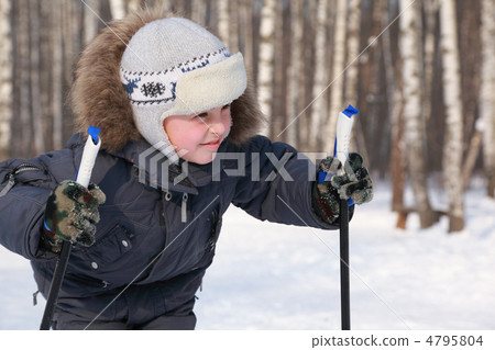 Portrait of young boy with ski poles looking to side inside wint Portrait of young boy with ski poles looking to side inside wint 4795804
