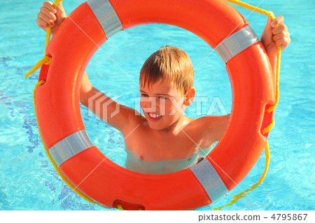 Cheerful little boy looks through red buoy from the swimming-poo 4795867