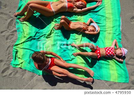 Mother and her children, son and two daughters, lying on the gre 4795930