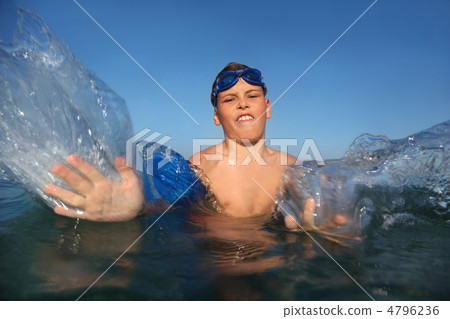 Boy in day-time bathes seaside and does waves hands Boy in day-time bathes seaside and does waves hands 4796236