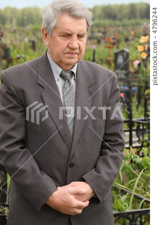 old sad senior in grey suit standing on cemetery and looking dow old sad senior in grey suit standing on cemetery and looking dow 4796244