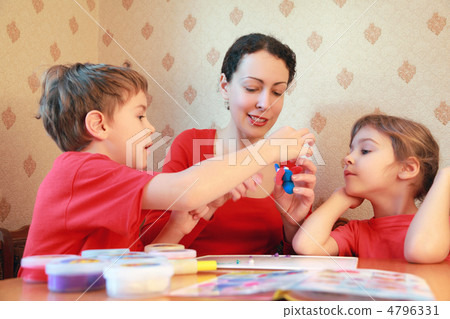 Mother and two children are at table and model from plasticine, Mother and two children are at table and model from plasticine, 4796331