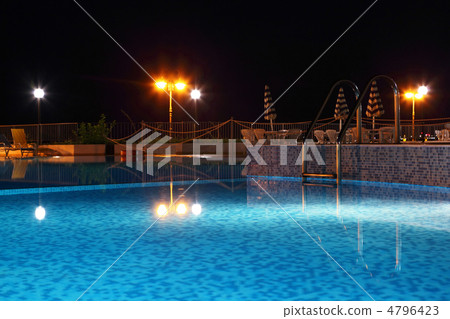 Night pool with lanterns, cafe and chairs near edge pool, focus 4796423