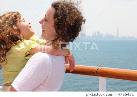 young mother carrying her daughter and laughing, standing on cru young mother carrying her daughter and laughing, standing on cru 4796431