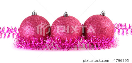 Three red Christmas tree balls surrounded by purple tinsel lies 4796595