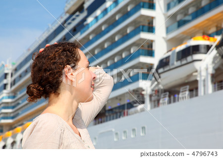 Smiling girl look at the big cruise ship and smooths hair by han Smiling girl look at the big cruise ship and smooths hair by han 4796743