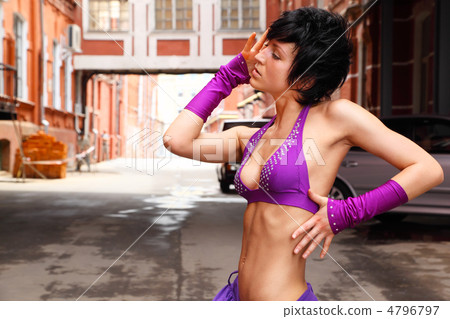 Slim girl in purple clothes posing on background of city street 4796797