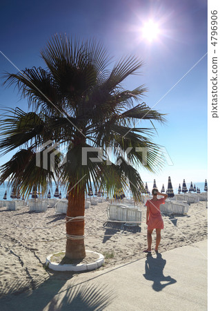 Woman in  morning stands on  beach after  protection near  palm 4796906