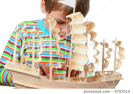 Small boy in striped shirt work with zeal on hull of artificial Small boy in striped shirt work with zeal on hull of artificial 4797014