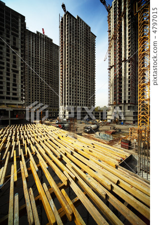 On wood planking between tall buildings under construction and c On wood planking between tall buildings under construction and c 4797015