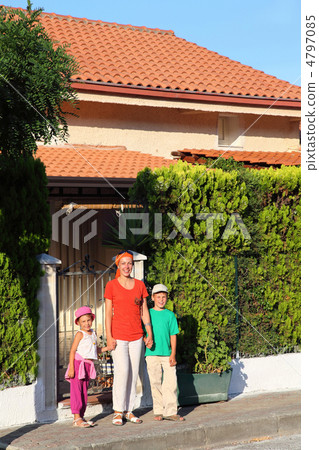 Mother with two children stands in day-time near included in ho Mother with two children stands in day-time near included in ho 4797085