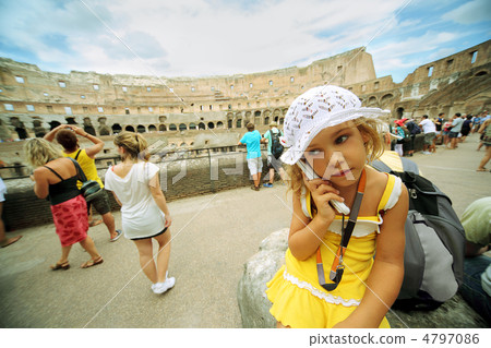 Little girl in yellow dress and white panama keeps electronic gu 4797086