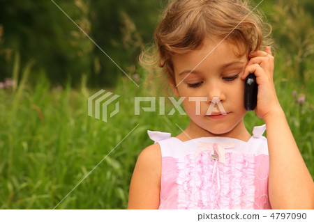 beautiful little girl in pink dress talking on cell phone outdoo 4797090