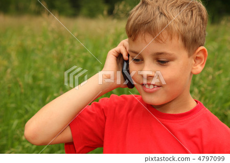 little boy in red shirt talking on cell phone outdoors. Boy smil little boy in red shirt talking on cell phone outdoors. Boy smil 4797099