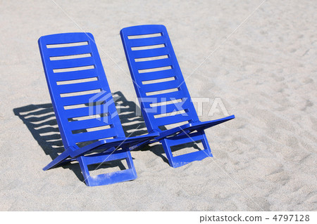 Two empty plastic chairs stand under sunbeams in  day-time on sa 4797128