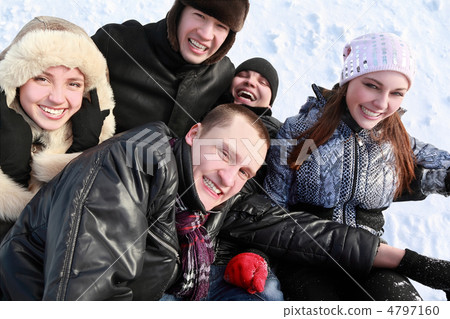 Young people by winter day lie on snow in heap and laugh 4797160
