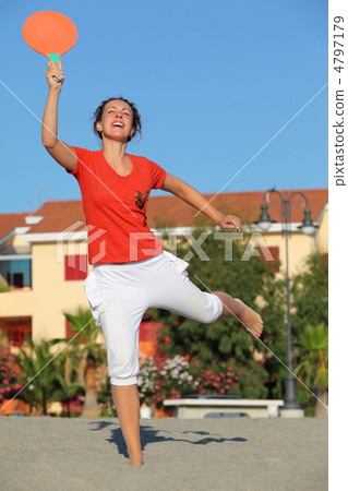 Woman jumps with  tennis racket on  beach by  sun day 4797179