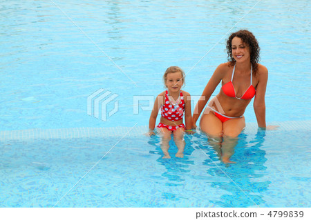 beautiful young mother in red bathing suit and her daugther sitt 4799839