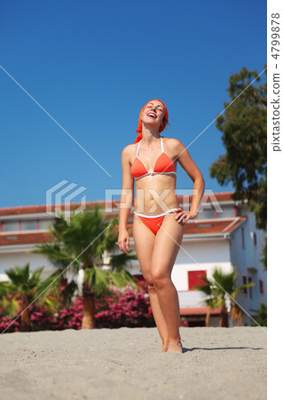 beautiful young woman in red swimsuit stands on beach and laughi 4799878