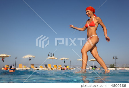 beautiful young woman in red swimsuit runs and dives into blue, 4800186