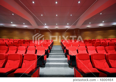 Rows of red arm-chairs are in  empty hall 4800464