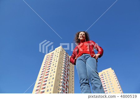 beautiful young woman in red jacket and blue jeans smiling. in b beautiful young woman in red jacket and blue jeans smiling. in b 4800519