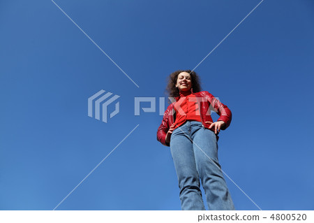 beautiful young woman in red jacket and blue jeans stand and smi beautiful young woman in red jacket and blue jeans stand and smi 4800520