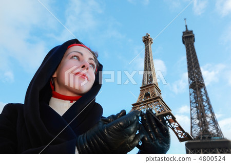 beautiful young woman holding souvenir, view of Eiffel Tower at 4800524