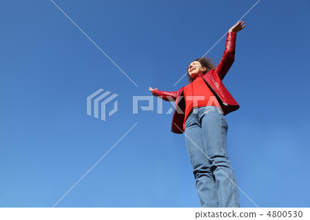 beautiful young woman in red jacket and blue jeans raises his ha beautiful young woman in red jacket and blue jeans raises his ha 4800530