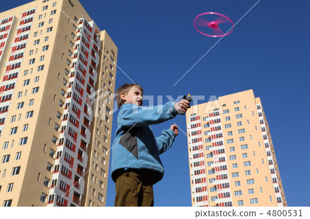 little boy in blue jacket plays with pink propeller. two yellow little boy in blue jacket plays with pink propeller. two yellow 4800531