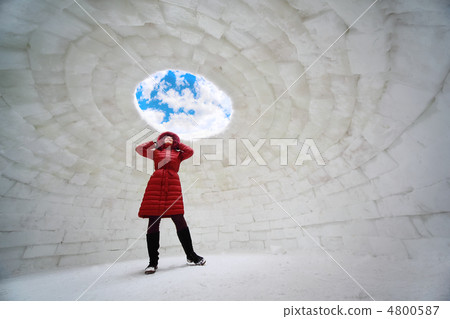 beautiful young woman in red jacket standing inside igloo at win 4800587