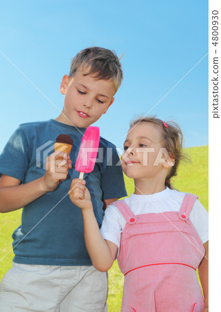 little boy and girl holding ice-creams and showing it to each ot 4800930