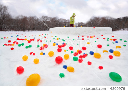 Little girl wearing green jacket playing with colored balls at w Little girl wearing green jacket playing with colored balls at w 4800976