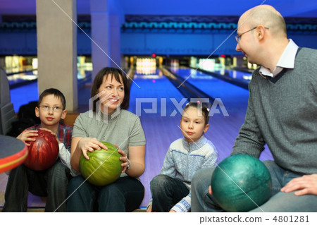 Four persons sit communicate in bowling club and hold balls, foc 4801281