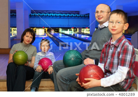 Mother, father and two children, sit in club and hold balls for 4801289