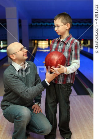 Father gives  son  red ball for bowling 4801312