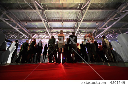 Crowd of spectators look at stage in evening; backs of people Crowd of spectators look at stage in evening; backs of people 4801349