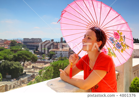 beautiful young woman with pink umbrella looks at Rome from Alta 4801376